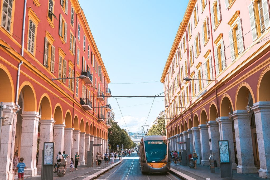A picture of a tram running through the streets of Nice. One reason Nice is not terribly expensive to visit is that it has an affordable public transportation network.