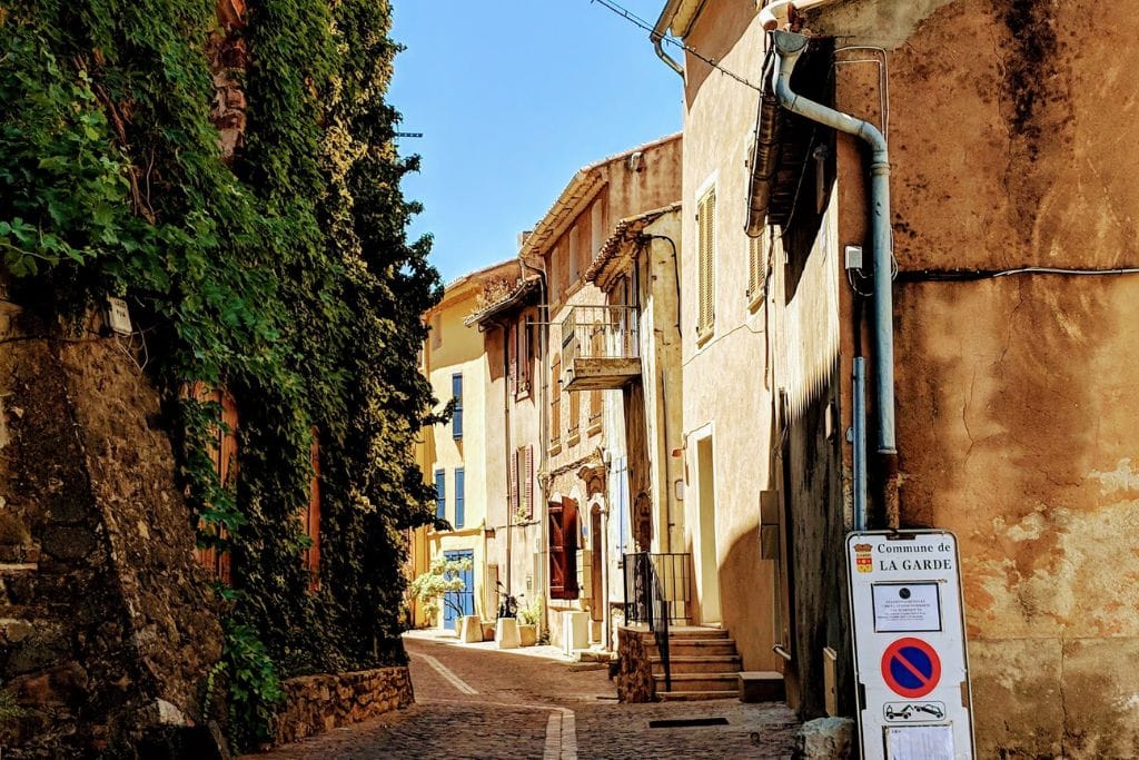 A picture of a small winding street in the South of France.