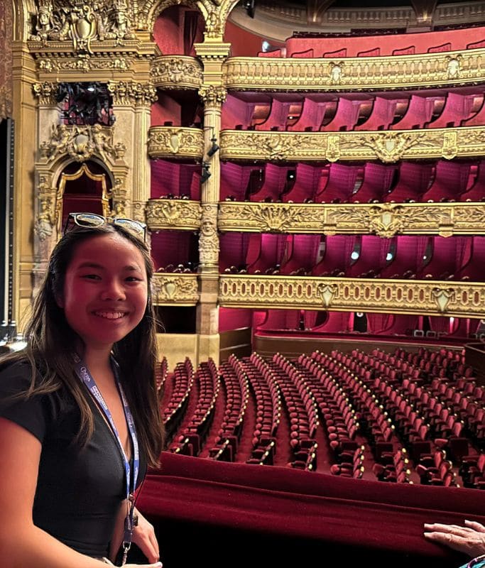 A picture of Kristin smiling in one of the box seats at the Paris Opera House.