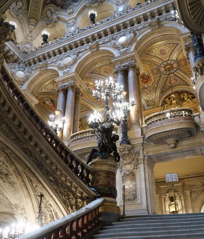 A picture of the decadent lamps that light the way on the grand staircase in the Paris Opera House.