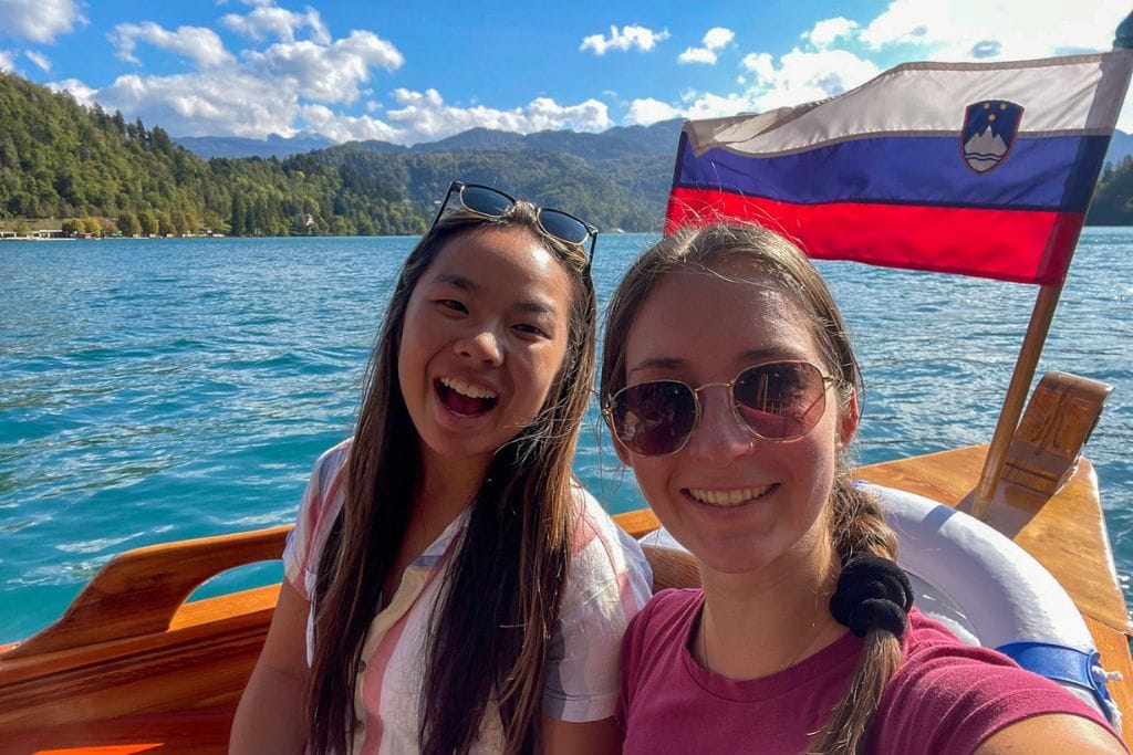 A picture of Kristin and her friend sailing across Lake Bled to Bled island in a traditional boat. 