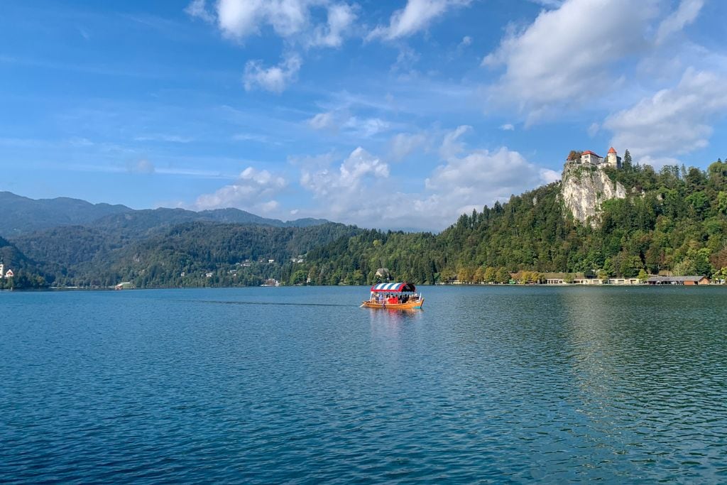 A picture of lake bled with bled castle in the background. Seeing this gorgeous landscape is one of the reasons lake bled is absolutely worth visiting.