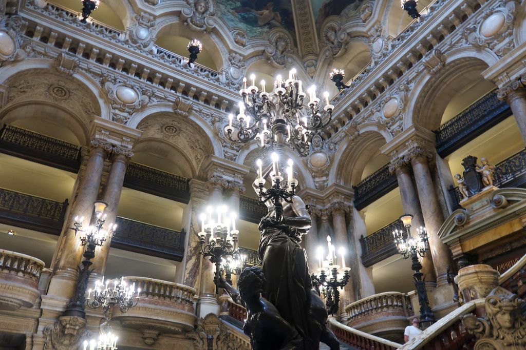 A picture of the main chandeliers and grandiose architecture in the surrounding the grand staircase.