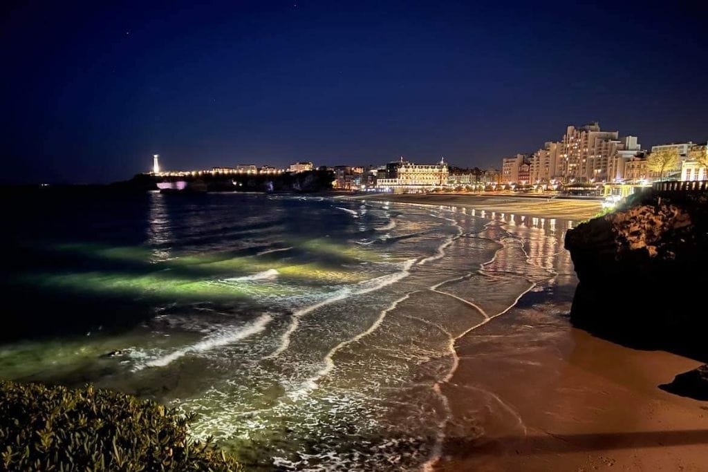 A picture of Biarritz and it's idyllic beach at night, lit up by the city lights.