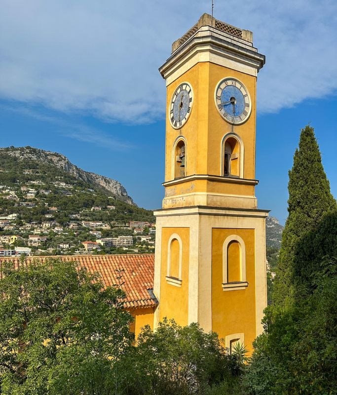 A picture of the yellow bell tower that's part of Notre Dame De L'Assumption church. 