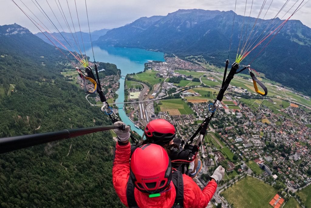 A picture taken from behind of Kristin and her pilot paragliding over Interlaken.