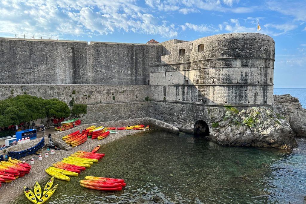 A picture of tons of kayaks lined up at the beach right outside of Dubrovnik's Old Town. This is where the majority of the Dubrovnik kayak tours depart from.