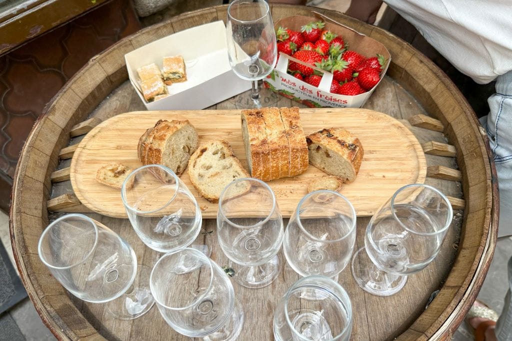 A picture of the wine tasting set up on my food tour in Nice. There was bread, strawberries, and a couple other food samples to eat as we drank wine.