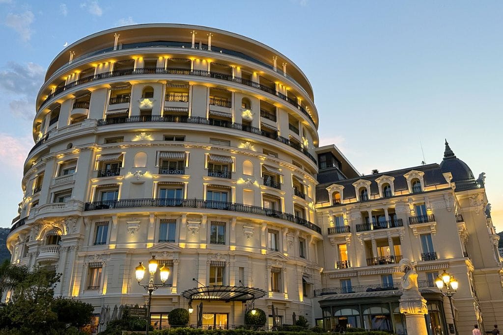 A picture of Monaco's Hotel de Paris lit up at night.