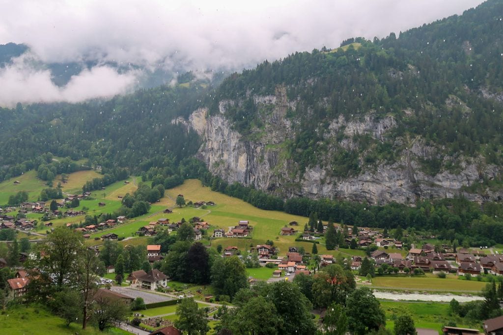 A picture of Lauterbrunnen Valley. You can see the towering mountainsides in the background.