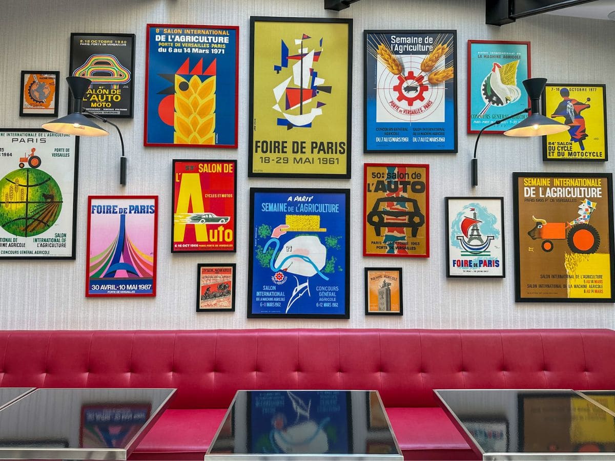 A picture of all the colorful posters along one of the walls in Hotel Moderniste's Winter Garden Room.