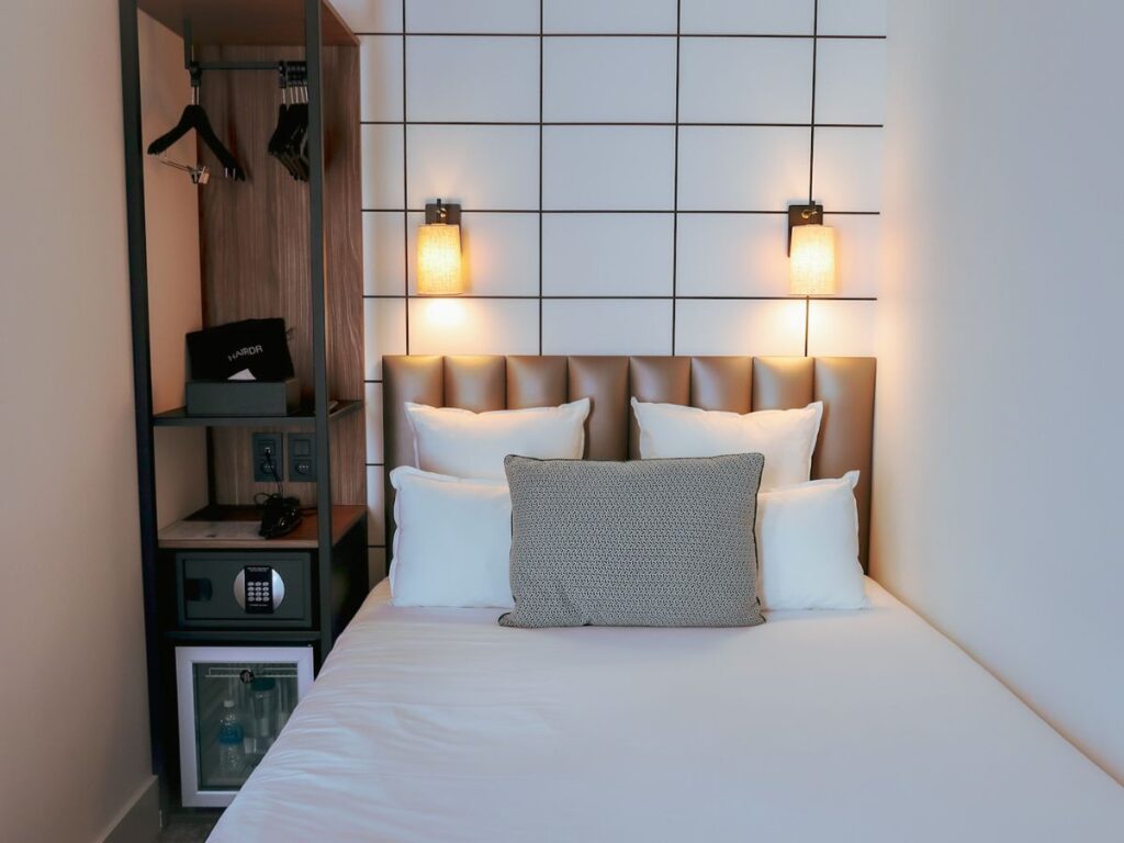 A picture of the soft lighting and nice bed in my room at Hotel Moderniste in Paris.