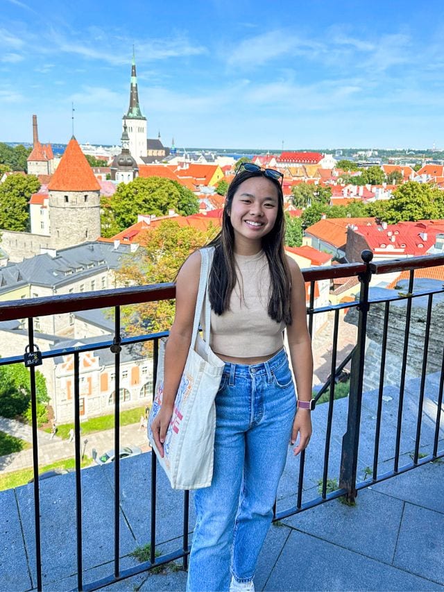 A picture of Kristin in Tallinn Estonia, with the medieval old town behind her.
