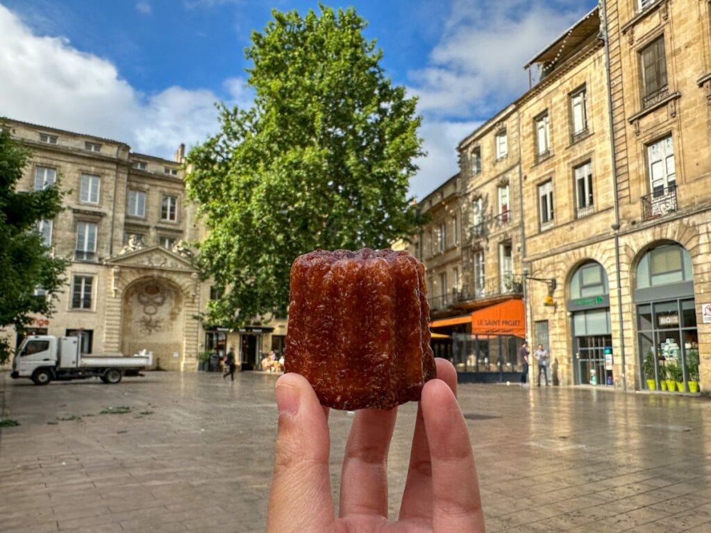 A picture of Kristin holding a Canele, which is a local specialty.  
