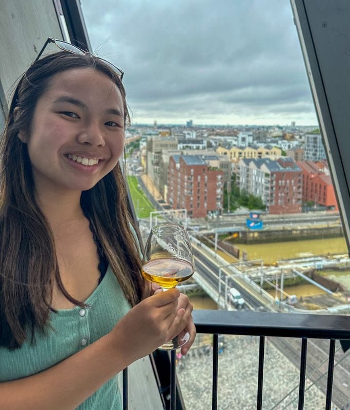 A picture of Kristin with a glass of wine in her hand from La Cite du Vin. For wine lovers or enthusiasts, I recommend doing a day trip to Bordeaux from Biarritz!