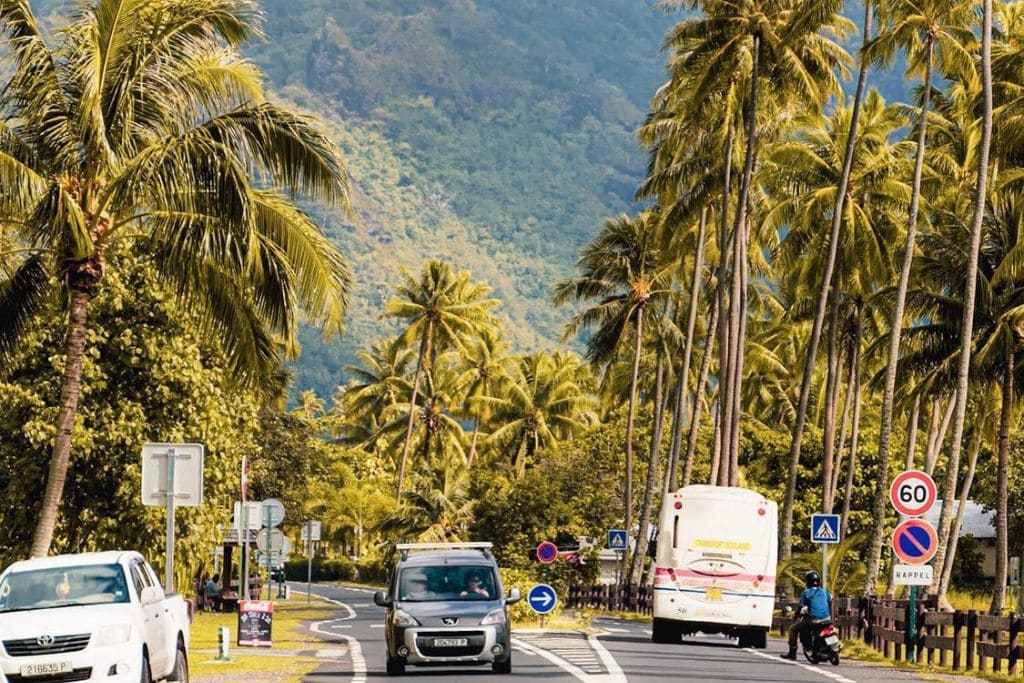 A picture of cars driving down the road in Tahiti.