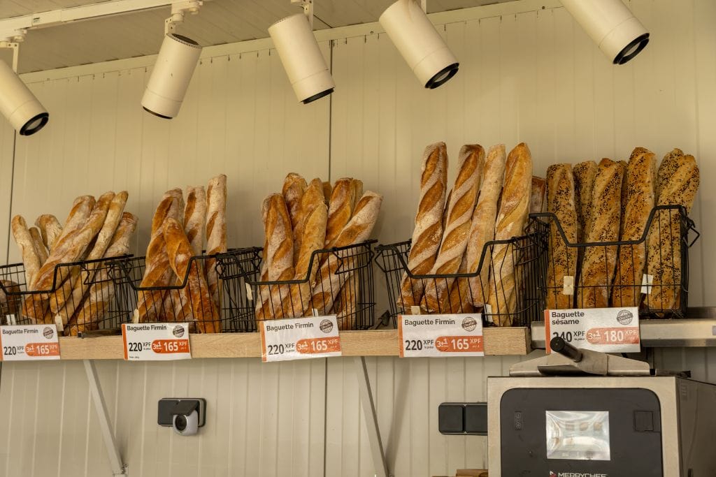 A picture of baguettes being sold at a local boulangerie in Tahiti. Looking for a cheap thing to do while you're in Tahiti? Eat baguettes!