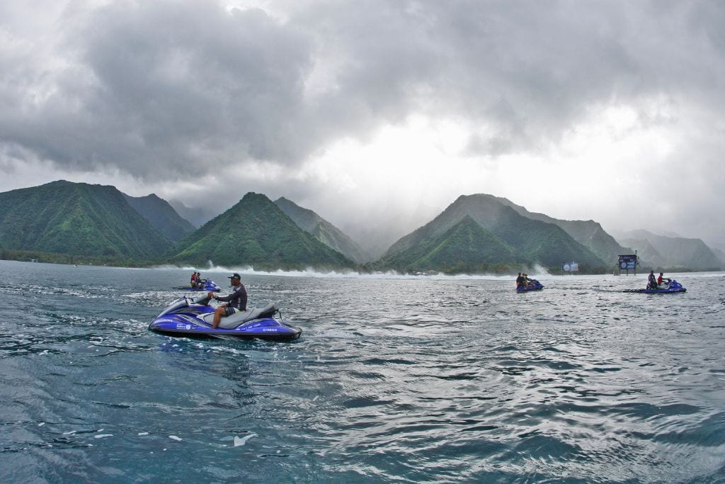 A picture of some people riding jet skis over the waters surrounding Tahiti.