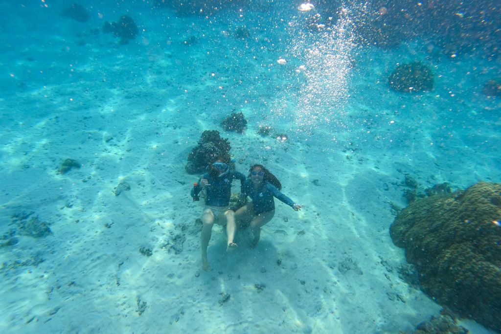 A picture of Kristin and her friend snorkeling in Tahiti. Snorkeling is one of the best things to do in Tahiti!