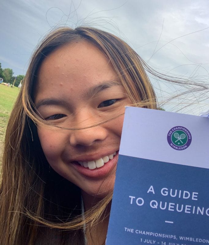 A picture of Kristin holding the official guide to queueing for Wimbledon. 