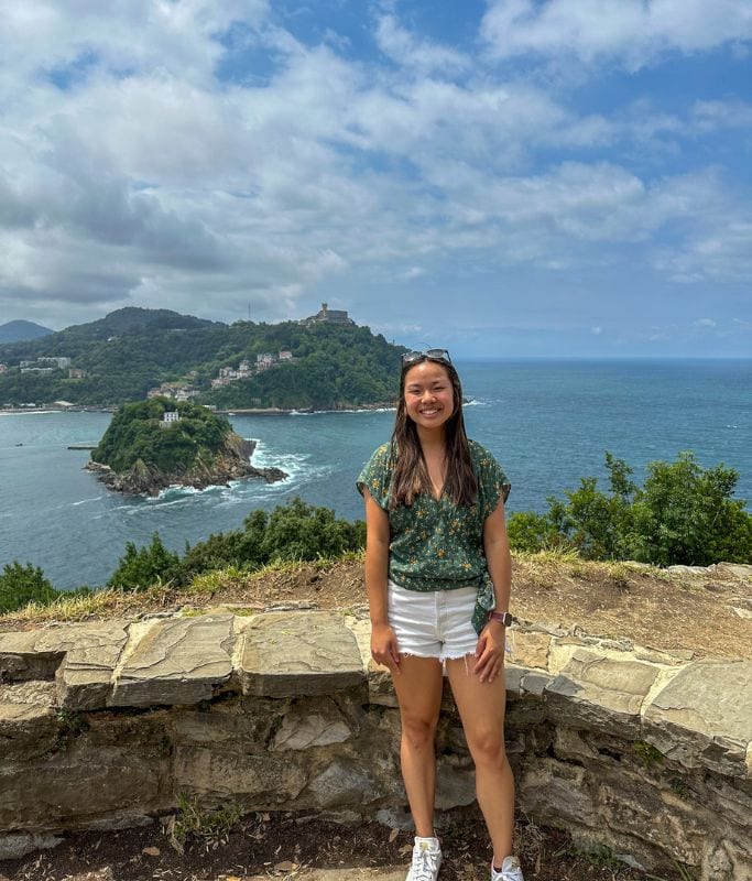 A picture of Kristin standing on top of Mont Urgell in San Sebastian with the beautiful bay in the background.