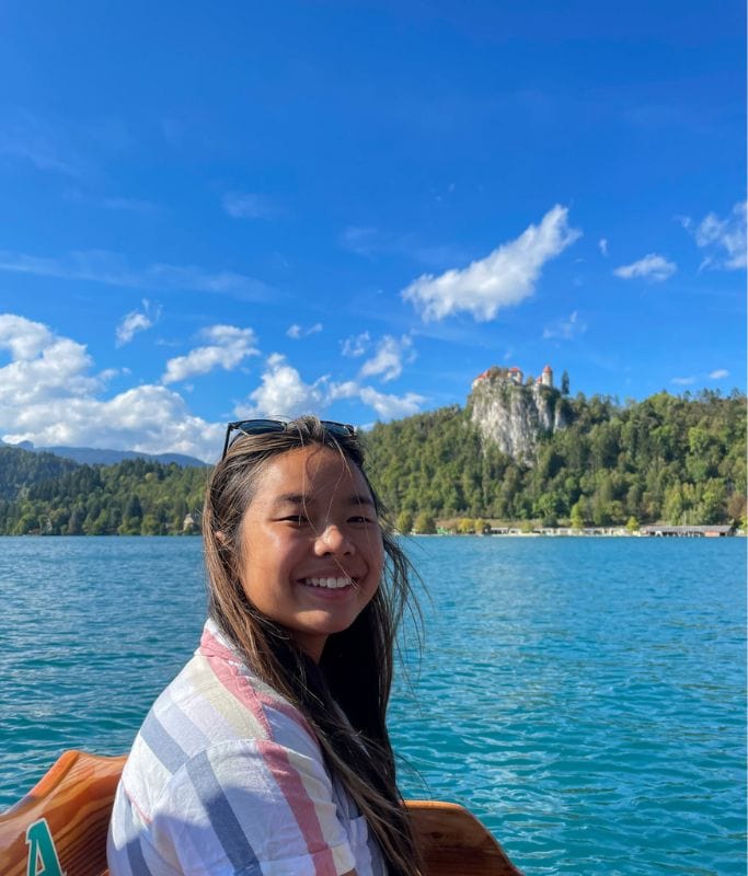 A picture of Kristin smiling while riding the boat gondola across Lake Bled.