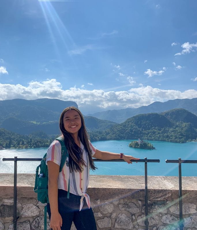 A picture of Kristin standing at the top of Bled Castle with Bled Island in the background.