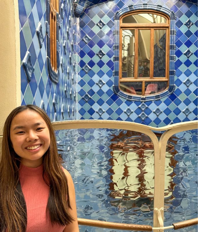 A picture of Kristin smiling next to the lightwell in Casa Batllo.