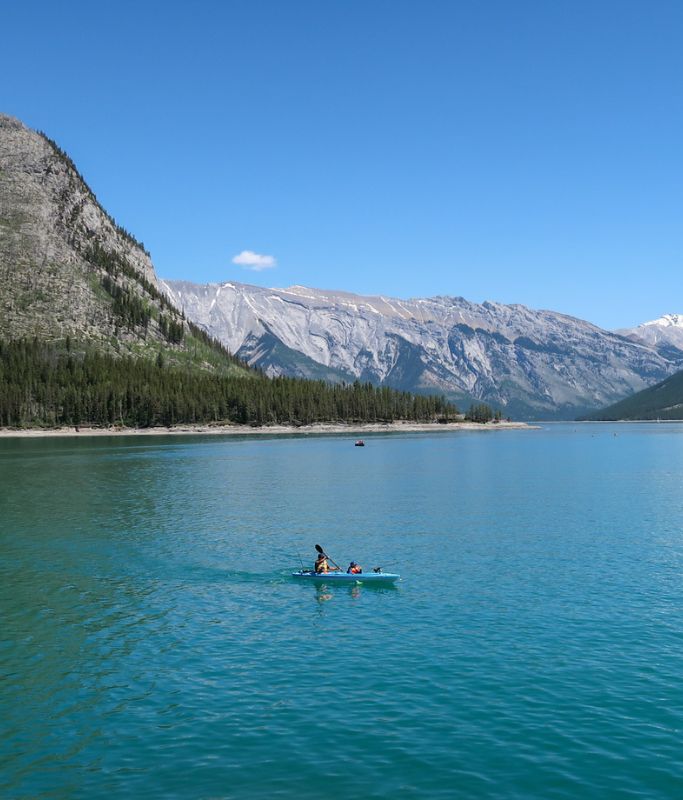 A picture of the beautiful landscape at Lake Minnewanka, our second stop on this 4-Day Banff Itinerary. The skies are clear and the water was a gorgeous turquoise blue.