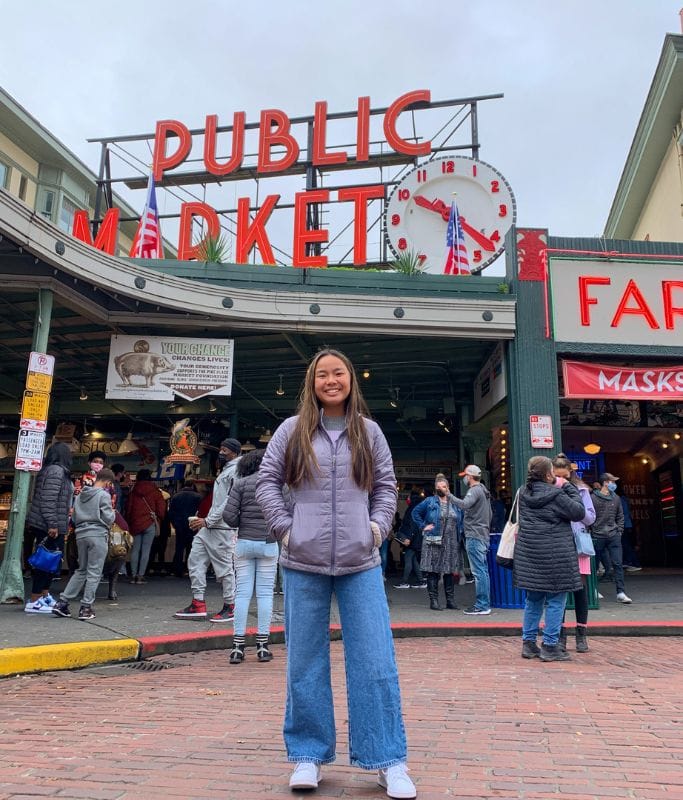 A picture of Kristin standing in front of the Pike Place Market.