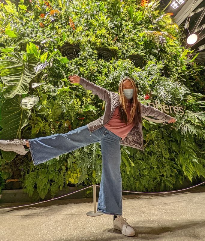 A picture of Kristin posing in front of plants at the Amazon Spheres in Seattle.