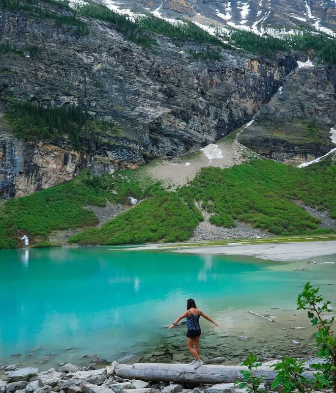 A picture of Kristin walking across a log in Banff. If you do one of the Calgary to Banff Tours, you'll be able to enjoy areas that don't have crowds and crowds of tourists!