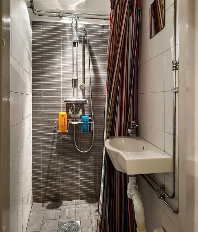 A picture of one of the shower stalls at Castanea Old Town Hostel Stockholm. You can see that shampoos and conditioners are provided for free for those who forget to bring their own.