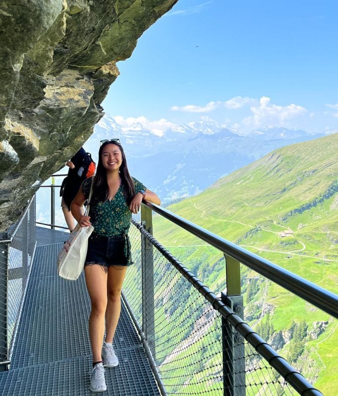 A picture of Kristin standing on the First Cliff Walk. If you love the kdrama Crash Landing on You, visiting Grindelwald is likely worth it to see all the filming sites!