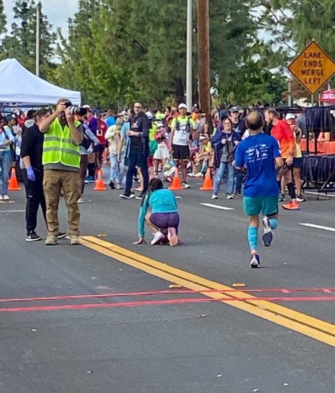 A picture of Kristin on the floor after crossing the finish line.