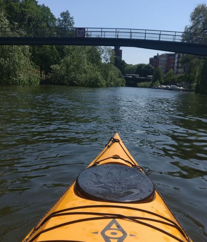 A picture of a yellow kayak while traversing the waterways of Stockholm.