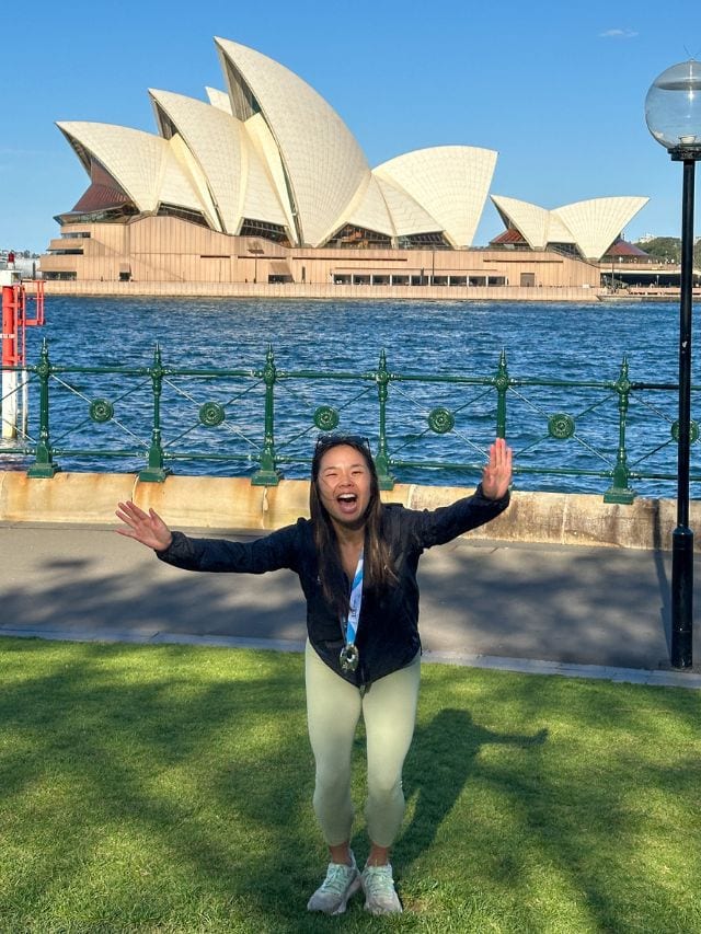 A picture of Kristin jumping with her medal after running the Sydney Marathon in Australia.